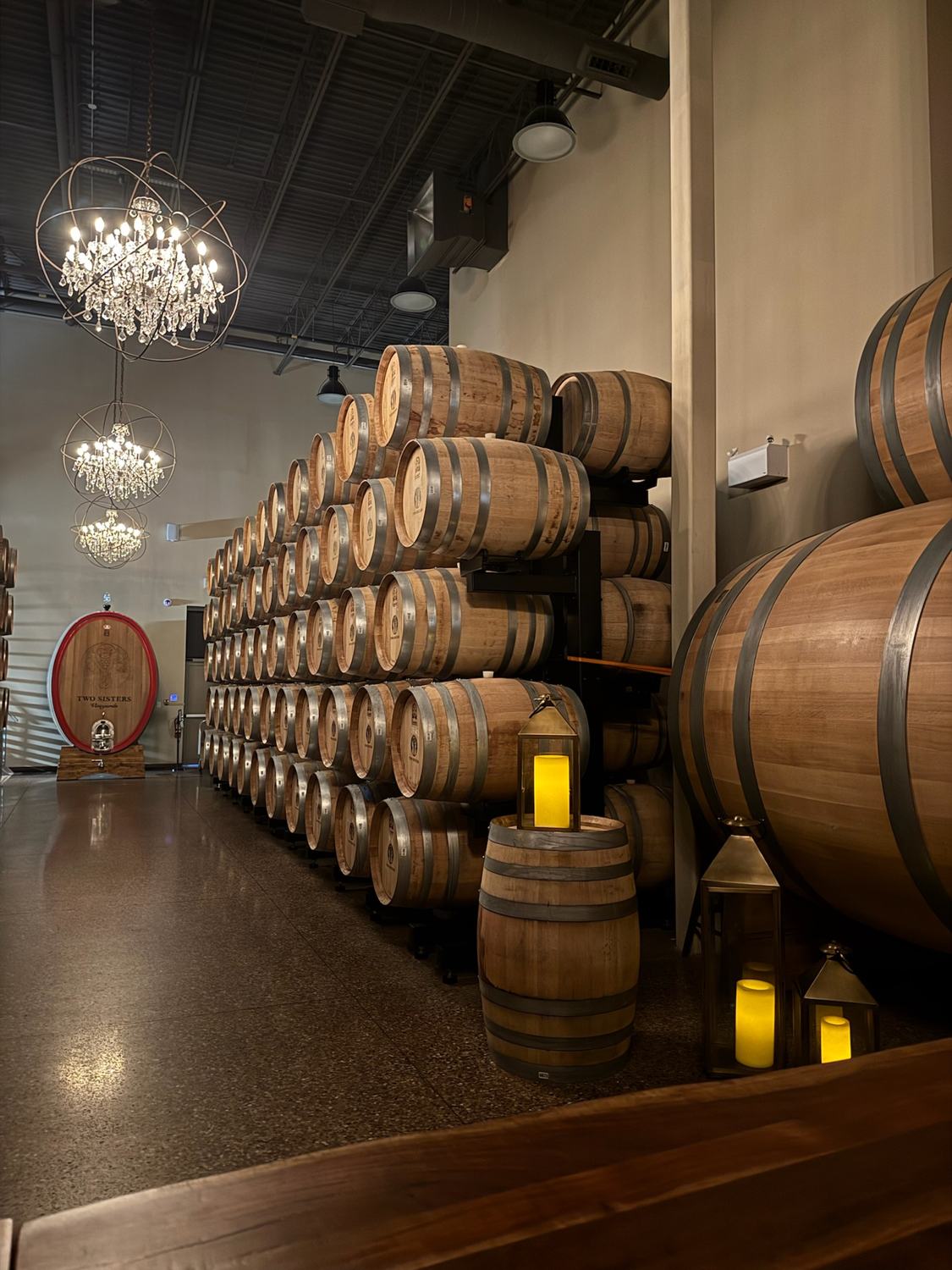 Barrels and candlelight beneath a chandelier