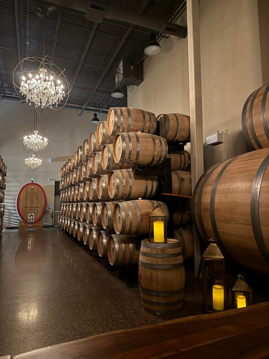 Oak barrels stacked beneath chandeliers