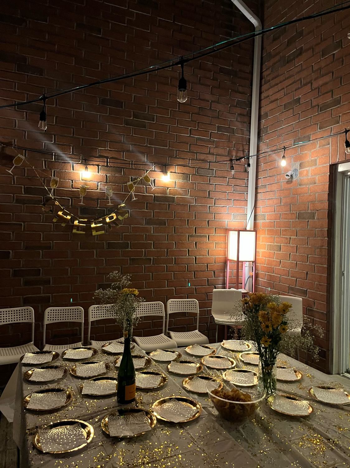 A long table set for dinner under string lights