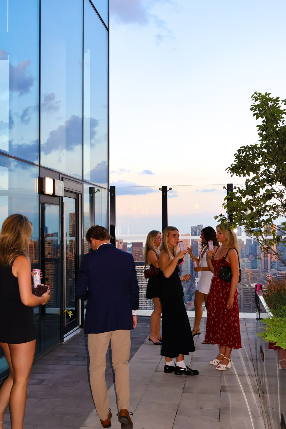 Guests talking on a rooftop terrace at sunset