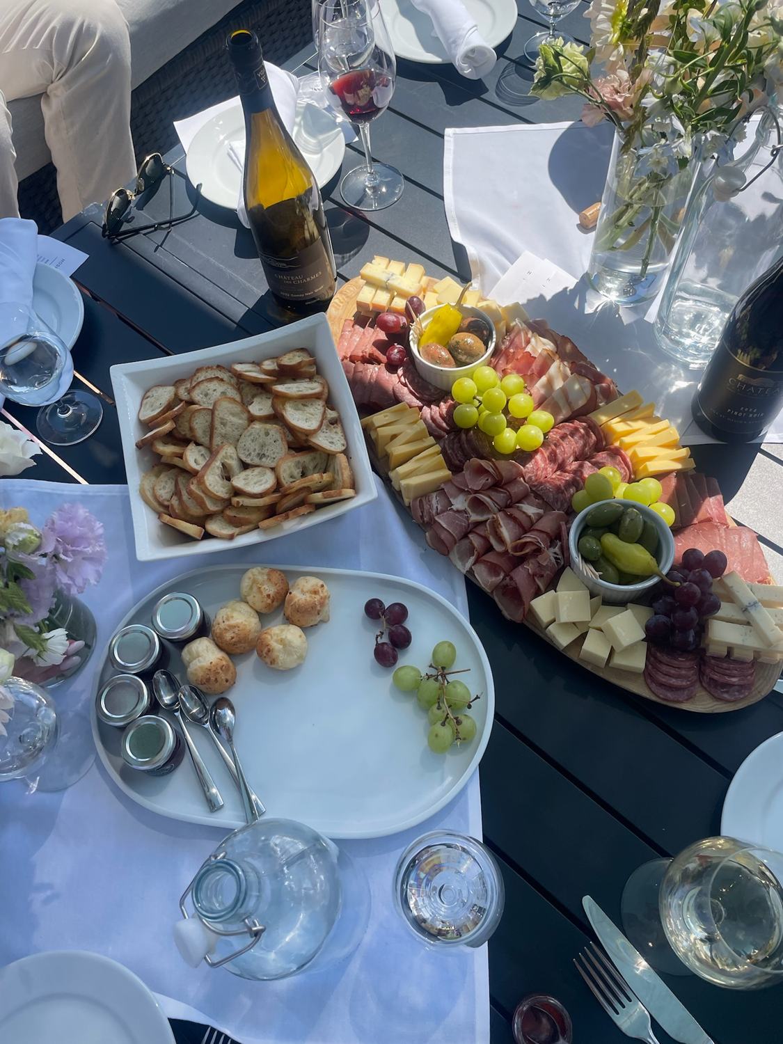 A charcuterie spread on a table by the vineyard
