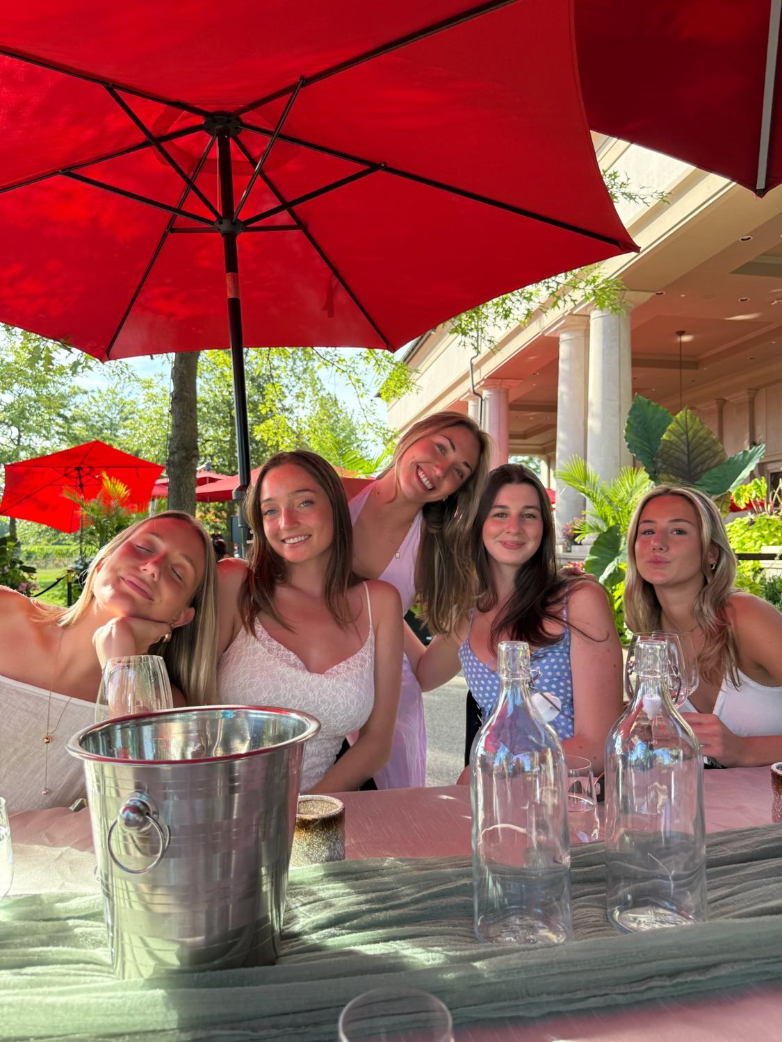 A group of members at a table under red umbrellas
