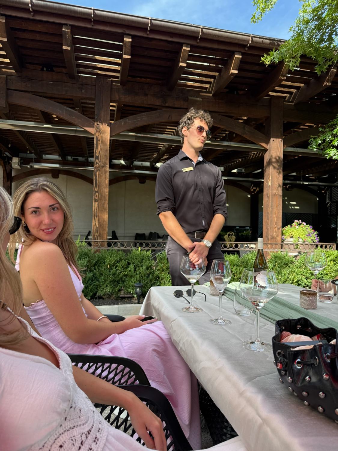 A member at a tasting table under the pergola
