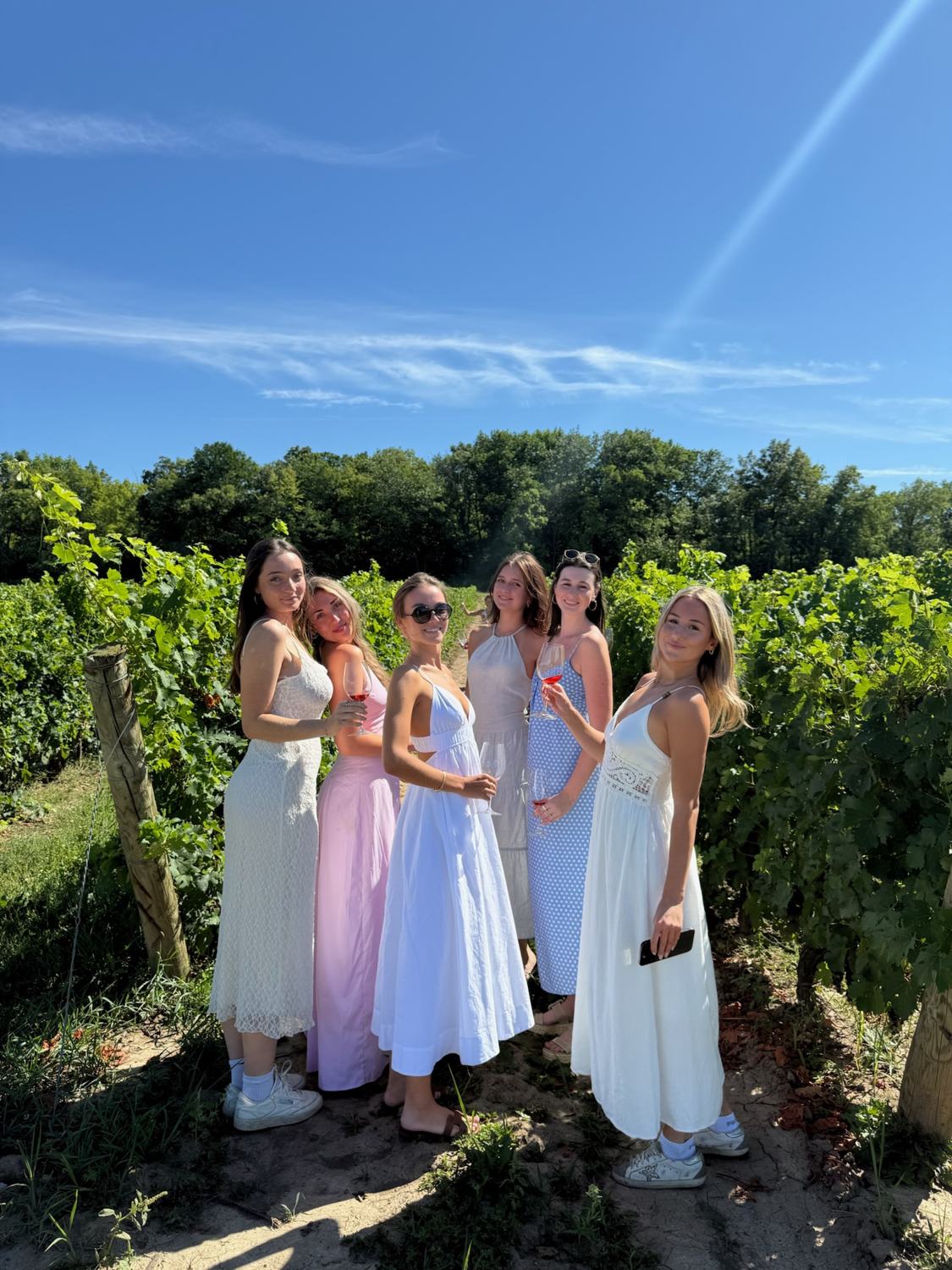 Members standing among the vines
