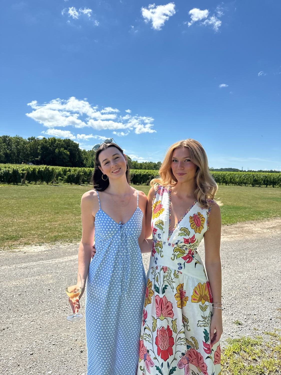 Two members in summer dresses beside the vineyard